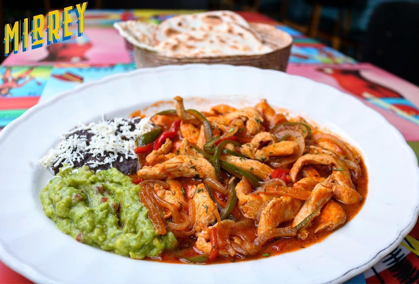 Fajitas servidas con guacamole, frijoles y tortillas en MirRey